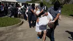 Petugas kepolisian menggelandang anggota geng Mara Salvatrucha di Zacatecoluca, El Salvador (31/1). 32 anggota geng tersebut dituduh membunuh pasukan keamanan dalam beberapa bulan terakhir. (AP Photo/Moises Castillo)