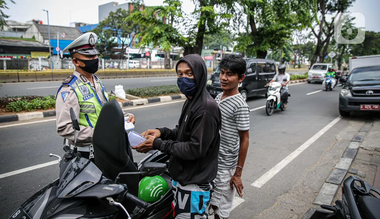 Polisi Lalu lintas menilang pengendara sepeda motor saat Operasi Patuh Jaya 2020 di Jalan Letjen Suprapto, Jakarta Pusat, Kamis (23/7/2020). Ditlantas Polda Metro Jaya menggelar Operasi Patuh Jaya 2020 hingga 5 Agustus untuk menertibkan masyarakat dalam berlalu lintas. (Liputan6.com/Faizal Fanani)