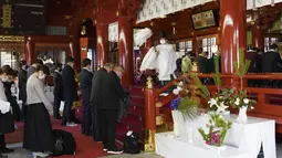Seorang pendeta berdoa untuk umat pada hari kerja pertama tahun ini di Kuil Kanda Myojin di Tokyo pada 4 Januari 2023. Pekerja dari sekitar 2.500 perusahaan membuat reservasi untuk mengunjungi kuil pada 4 dan 5 Januari saja, kata seorang pejabat kuil. (AFP/Kazuhiro Nogi)