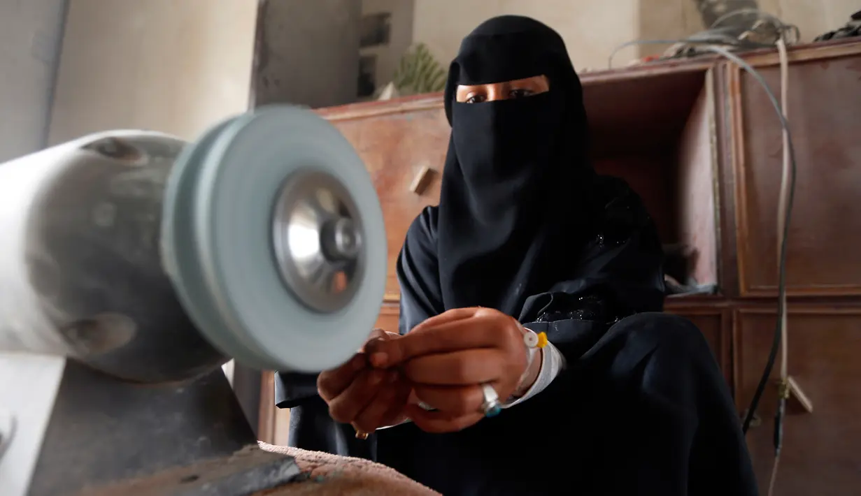 Seorang wanita bernama Safa al-Faqih mengasah batu mulia di tempat kerajinan di Sanaa, Yaman (18/4). Karena perang yang terjadi di Yaman hanya seperempat pengrajin masih bekerja di pasar lama Sanaa. (AFP/Mohammed Huwais)