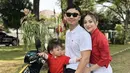 Nikita Willy mengenakan kemeja panjang merah, dipadukan celana putihnya. Kompak dengan baby Izz dan suami. [Instagram/@nikitawillyofficial94]