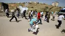 Wartawan Palestina berlari berhamburan setelah gas air mata ditembakkan pasukan Israel saat meliput aksi protes yang menyerukan pembebasan wartawan Palestina, Omar Nazzal di dekat Penjara Ofer Israel di Ramallah, Israel (26/4).(REUTERS / Mohamad Torokman)