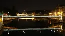 Pandangan umum jembatan Arcole dan Louis Philippe tercermin di sungai Seine pada malam hari selama penerapan lockdown atau penguncian wilayah di Paris, 23 April 2020. Pandemi corona COVID-19 membuat Prancis menerapkan lockdown. (Ludovic MARIN / AFP)