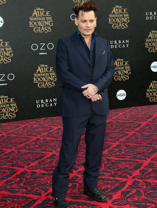 Aktor tampan Johnny Depp berpose saat menghadiri premiere film 'Alice Through The Looking Glass' di Hollywood, California, 23 Mei 2016. Pria 52 tahun itu tampil dengan setelan biru dongker. (Frederick M. Brown/GETTY IMAGES NORTH AMERICA/AFP)