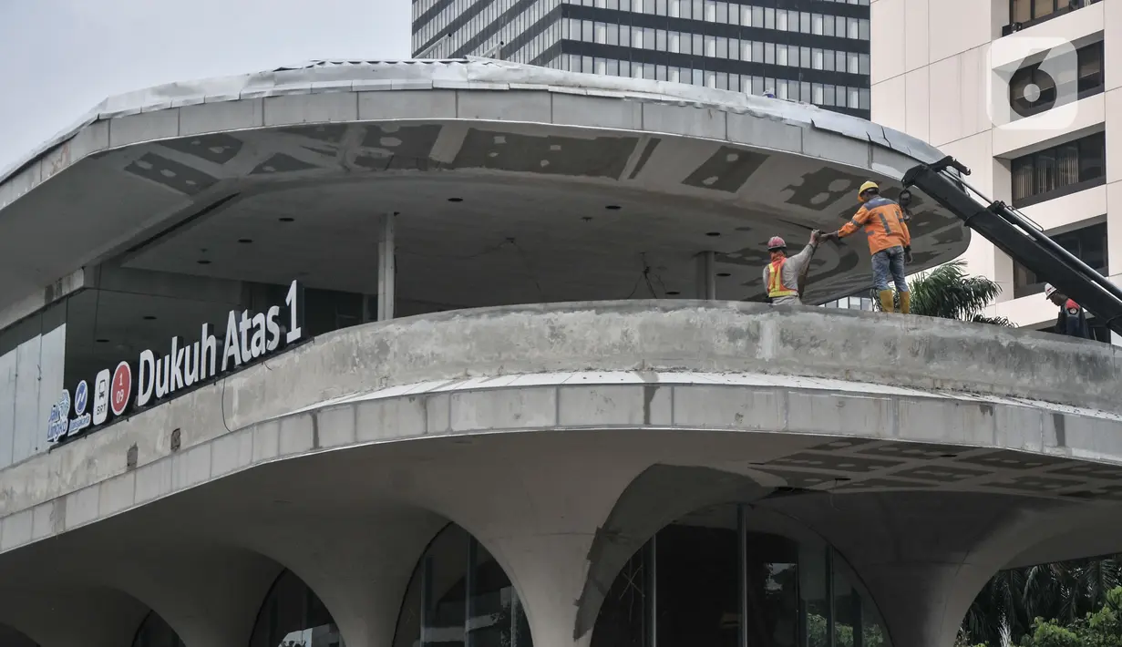 Pekerja saat menyelesaikan proyek pembangunan halte Transjakarta Dukuh Atas 1 di Jalan Jenderal Sudirman, Jakarta Pusat, Kamis (5/1/2023). Direktur Teknik dan Digital Transjakarta Mohamad Indrayana mengungkapkan pada 2023 PT TransJakarta menargetkan dapat menyelesaikan 54 halte yang sudah siap beroperasi untuk kepentingan mobilitas warga. (merdeka.com/Iqbal S Nugroho)