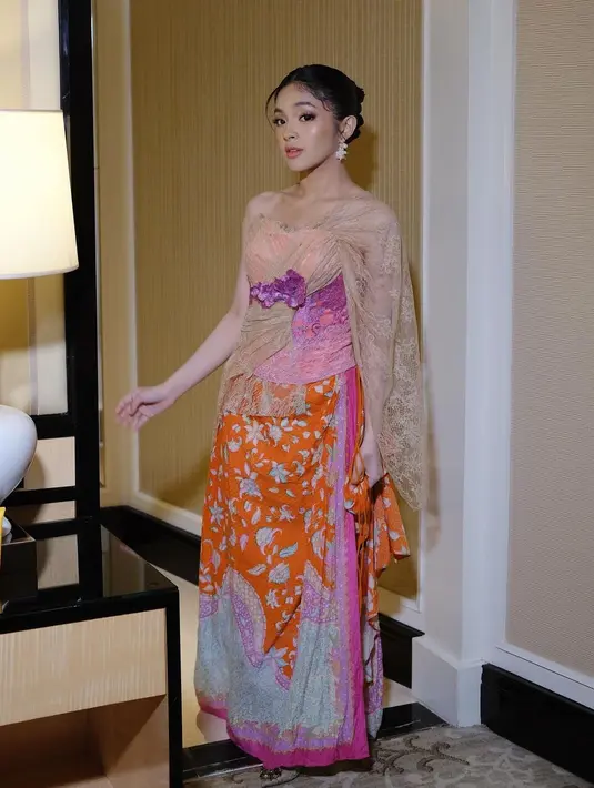 Kain batik panjang ini ia lilitkan sebagai rok dan sentuhan warna pink dan ungu di ujung-ujung kain senada dengan penampilannya secara keseluruhan. [Foto: Instagram/elsaajapasal]