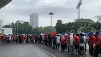 Antrean fans mengular di depan akses tribun Stadion Utama Gelora Bung Karno jelang menyaksikan laga Timnas Indonesia vs Filipina pada Selasa (11/6/2024). (Liputan6.com/Melinda Indrasari)