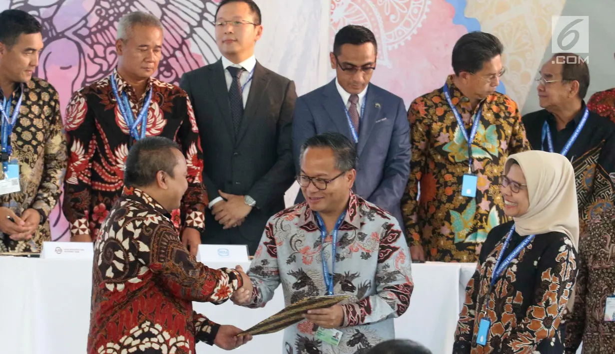 Kepala Eksekutif Pengawas Pasar Modal OJK Hoesen menyalami Dirut Bank Mandiri Kartika Wirjoatmodjo usai penandatanganan KIK DINFRA yang diterbitkan Mandiri Sekuritas dalam IIF 2018 di Nusa Dua, Bali, Kamis (11/10).  (Liputan6.com/Angga Yuniar)
