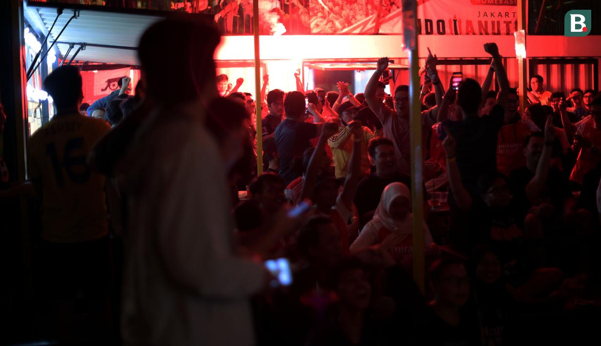 Selebrasi komunitas Arsenal Indonesia saat tim kesayangannya menjebol gawang Liverpool dalam acara Roaring Night pertandingan Premier League 2023/2024 antara Liverpool melawan Arsenal yang berlangsung di Pitch 98, Kemang, Jakarta, Minggu (24/12/2023) dini hari. (Bola.com/Bagaskara Lazuardi)
