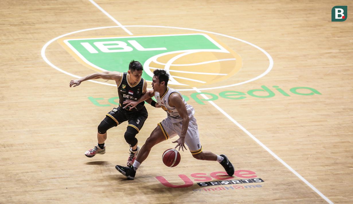 Pemain Tangerang Hawks Basketball Club, Vlocky Rachmalo (kanan) berebut bola dengan pemain Dewa United Surabaya, Nikholas Mahesa R saat laga lanjutan Seri 1 IBL 2022 di Hall Basket GBK, Senayan, Kamis (20/01/2022). (Bola.com/Bagaskara Lazuardi)