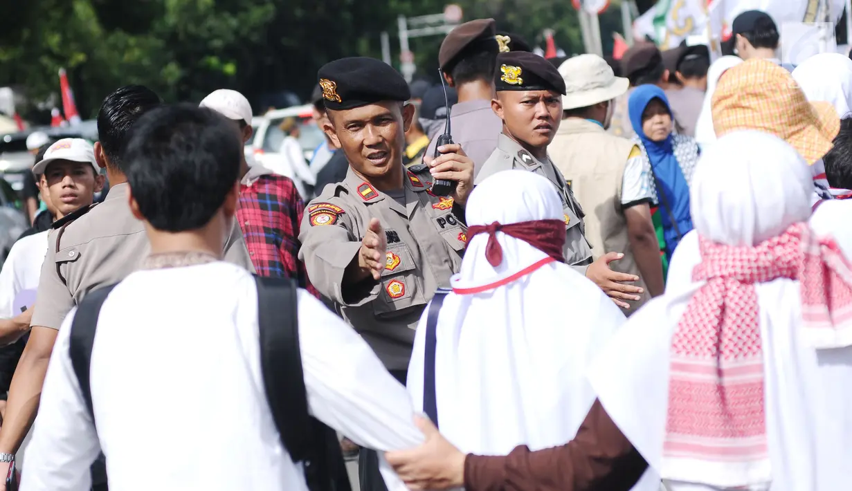 Polisi mengatur arus masuk massa aksi unjuk rasa di depan Kedubes AS, Jakarta, Minggu (10/12). Ribuan massa berkumpul memprotes keputusan Presiden Trump yang mengakui Yerusalem jadi Ibu Kota Israel. (Liputan6.com/Helmi Fithriansyah)