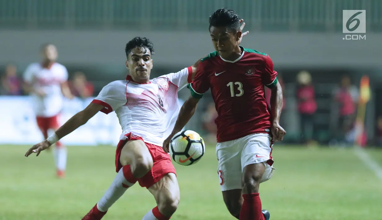 Gelandang Indonesia U-23, Febri Hariyadi (kanan) berebut bola dengan pemain Bahrain pada laga PSSI Anniversary 2018 di Stadion Pakansari, Kab Bogor, Jumat (27/4). Babak pertama Indonesia tertinggal 0-1. (Liputan6.com/Helmi Fithriansyah)