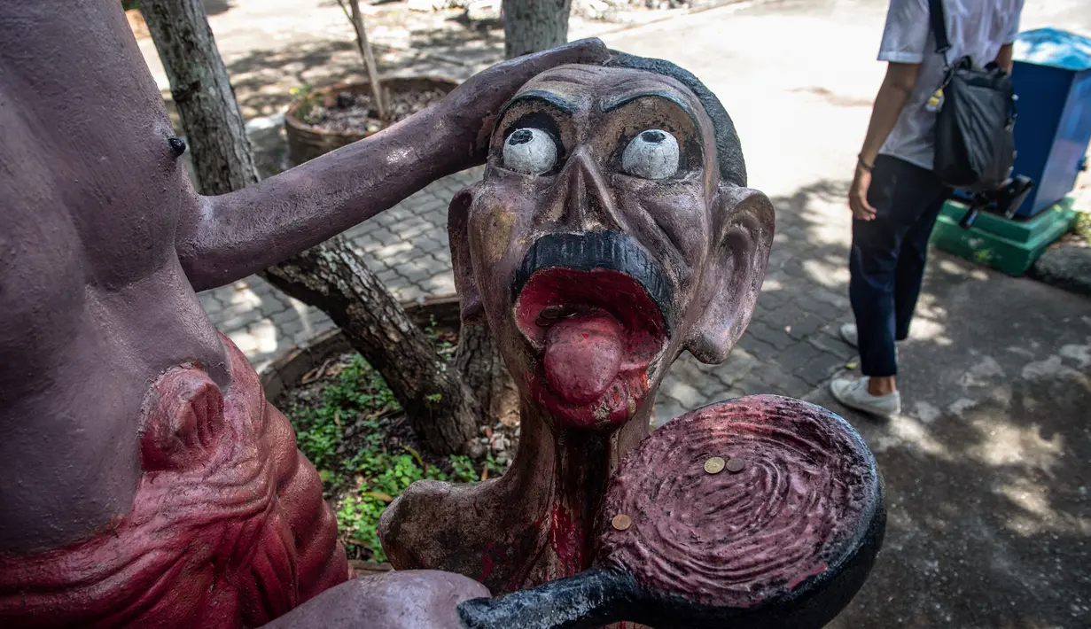 Patung-patung menggambarkan nasib orang-orang yang melakukan perbuatan buruk di sebuah taman yang menggambarkan neraka versi Buddha di kuil Wat Saeng Suk di provinsi pesisir Thailand, Chonburi (9/7/2020). (AFP/Lillian Suwanrumpha)