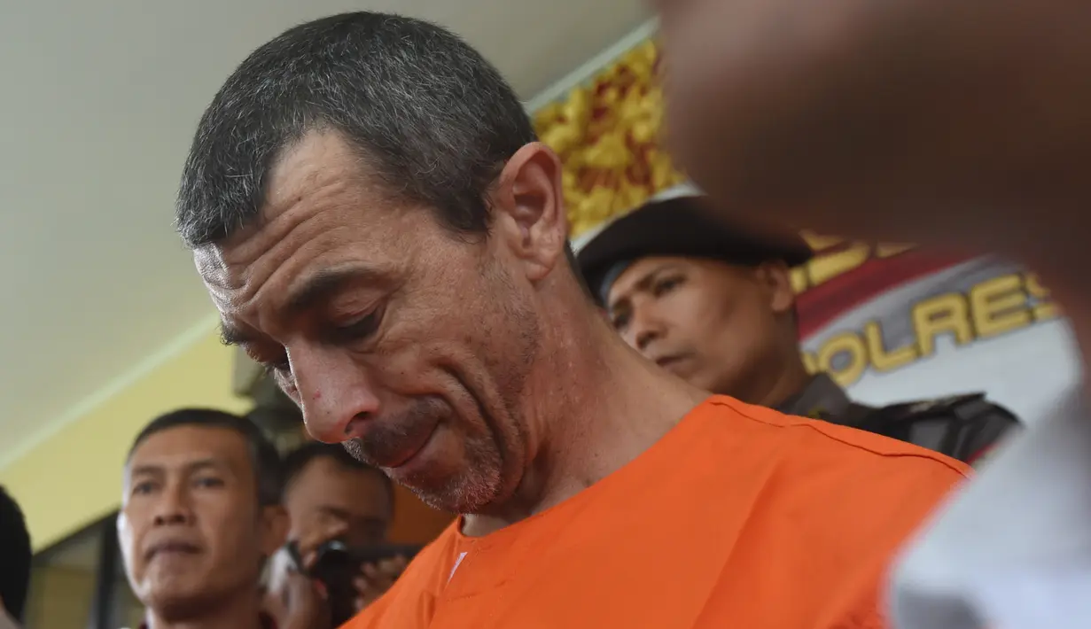 Warga negara Prancis Samuel Pierre Danguny tertunduk saat konferensi pers di kantor polisi di Denpasar, Bali (18/3). Danguny ditangkap pada 15 Maret dengan kepemilikan 33 gram ganja dan 2 paket Hasis 16 gram. (AFP Photo/Sonny Tumbelaka)