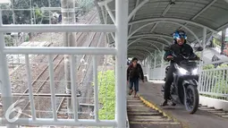 Pengendara motor melintas di jembatan penyeberangan orang (JPO) di kawasan Pasar Minggu, Jakarta, Selasa (6/9). JPO yang seharusnya diperuntukkan bagi pejalan kaki, kini seringkali digunakan pemotor untuk menyeberang. (Liputan6.com/Immanuel Antonius)
