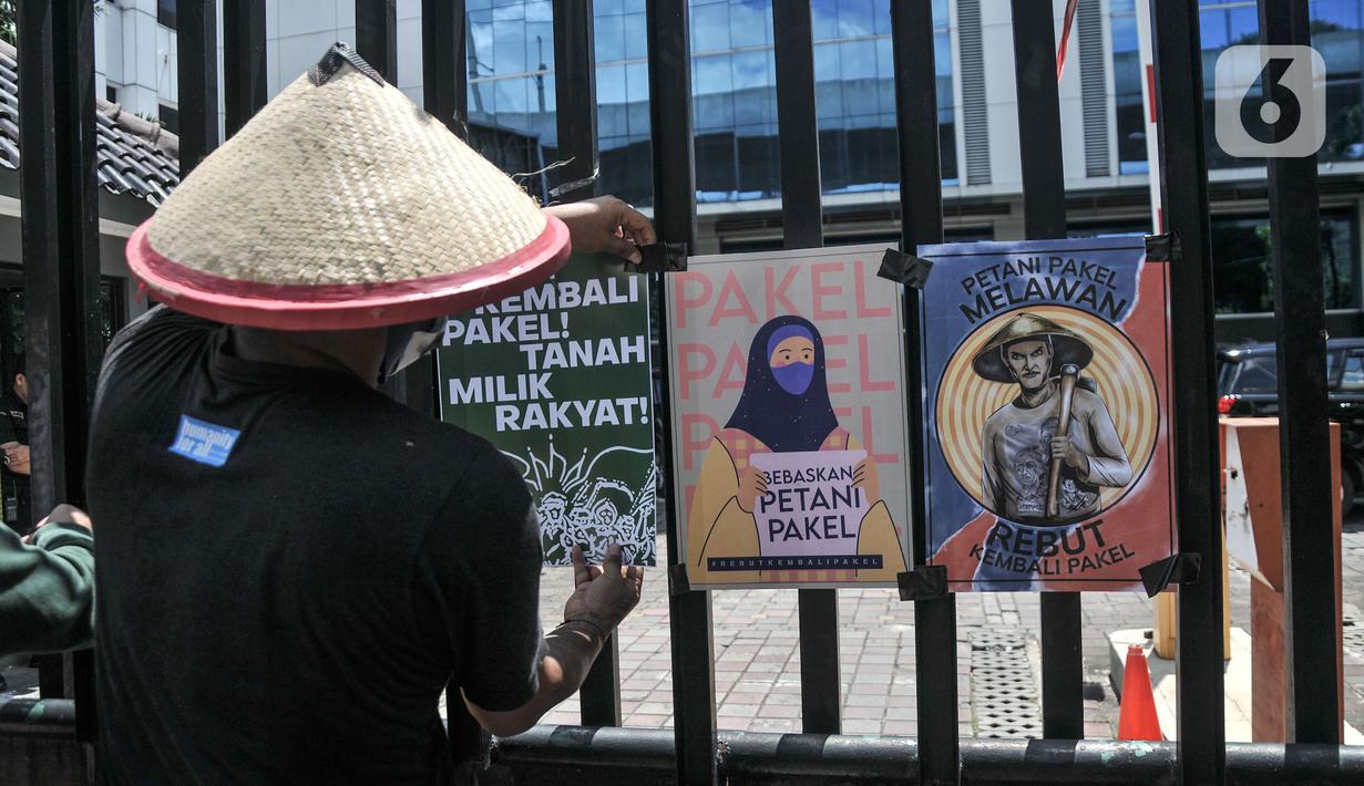 Aktivis Gerakan Rakyat untuk Kedaulatan Agraria memasang poster saat aksi mogok makan di depan Kantor Kementerian ATR/BPN, Jakarta, Senin (20/2/2023). Mereka juga menuntut Presiden Joko Widodo menyelesaikan kasus warga Pakel Banyuwangi dan memulihkan hak-hak ekonomi, sosial, budaya mereka yang terampas. (merdeka.com/Iqbal S Nugroho)