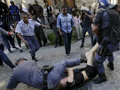Polisi bentrok dengan pelajar di luar Parlemen Afrika Selatan di Cape Town, Rabu (21/10). Polisi anti huru hara menembakkan gas airmata kepada ratusan pelajar yang berdemonstrasi menentang rencana kenaikan uang sekolah. (REUTERS/Mark Wessels)