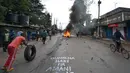 Massa membakar ban dan turun ke jalan saat menggelar protes terkait pemilihan presiden Kenya di Kibera, Nairobi, Kenya (9/8). Kerusuhan terjadi setelah badan pemilihan menyatakan Uhuru Kenyatta sebagai pemenang pemilihan presiden. (AFP Photo/Tony Karumba)