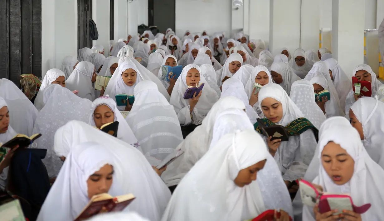 Puluhan santri membaca Al Quran saat tadarus massal awal Ramadhan 1440 H di Pesantren Ar-Raudhatul Hasanah, Medan, Sumatera Utara pada 6 Mei 2019. Tadarus yang diikuti sedikitnya 3.200 santri tersebut merupakan kegiatan rutin selama bulan Ramadan di pesantren itu. (REUTERS/Ahmad Ridwan Nasution)