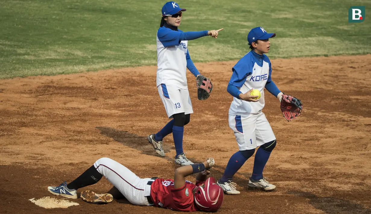 Atlet softball Indonesia, Ilka Emogene, terjatuh saat melawan Korea Selatan pada laga Asian Games di Lapangan Softball Senayan, Jakarta, Selasa (21/8/2018). Indonesia kalah 2-4 dari Korsel. (Bola.com/Vitalis Yogi Trisna)