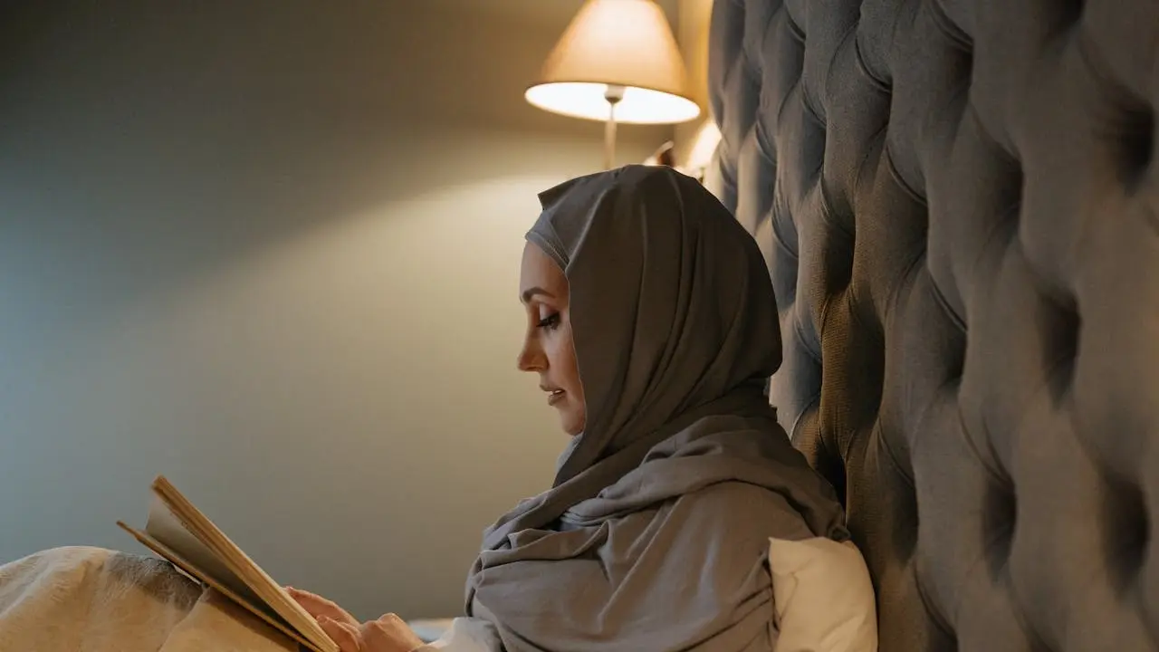 Wanita muslim membaca buku di kasur