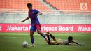 Pemain Barcelona U-18 Jorge Javier Espinal Díaz (kiri) menggiring bola melewati kiper Bali United U-18 I Komang Aryantara pada pertandingan International Youth Championship (IYC) 2021 di Jakarta International Stadium (JIS), Jakarta, Minggu (17/4/2022). (Liputan6.com/Faizal Fanani)