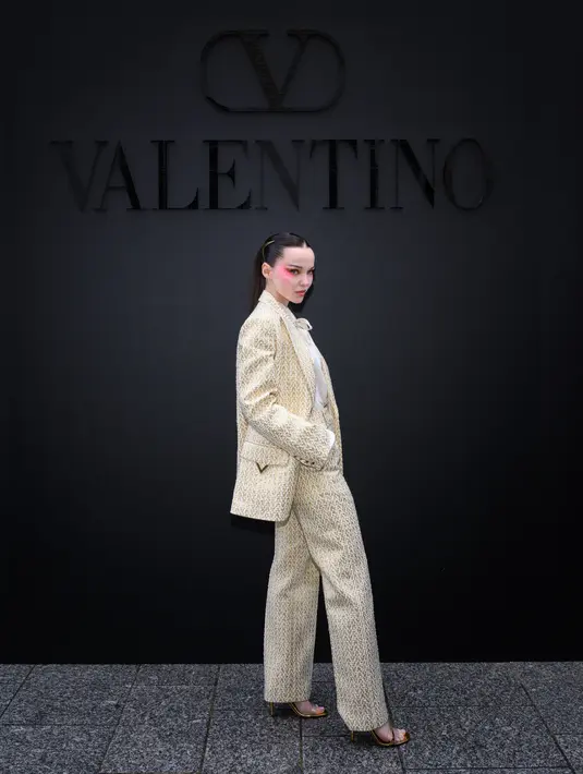Dove Cameron juga hadir mengenakan set tweed blazer berwarna ivory. Dipadukan dengan kemeja putih menampilkan gaya lady boss yang simple tapi elegan.(Valentino)