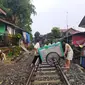 Warga tengah menyeberang rel bersama gerobaknya di kawasan Bogor, Jawa Barat. (Liputan6.com/Achmad Sudarno)