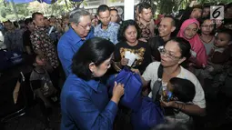 Ketua Dewan Pembina Partai Demokrat Susilo Bambang Yudhoyono atau (SBY) didampingi Ani Yudhoyono memberikan langsung paket sembako kepada warga saat peresmian Gerakan Pasar Murah Demokrat di Jakarta, Kamis (7/6). (Liputan6.com/Iqbal Nugroho)