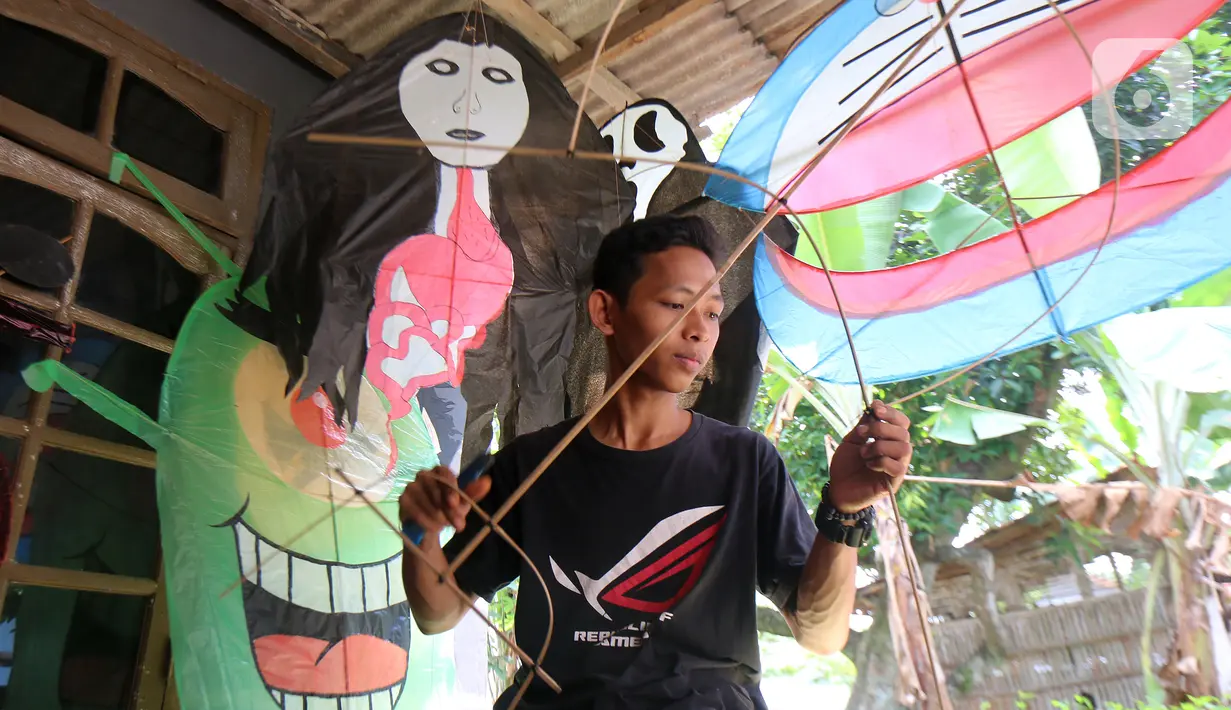 Perajin menyelesaikan pembuatan layang-layang Koang di Bedahan, Depok, Jawa Barat, Senin (20/7/2020). Kerajinan layangan berbahan rangka bambu, plastik, dan kain ramai diburu pada musim kemarau. (Liputan6.com/Fery Pradolo)