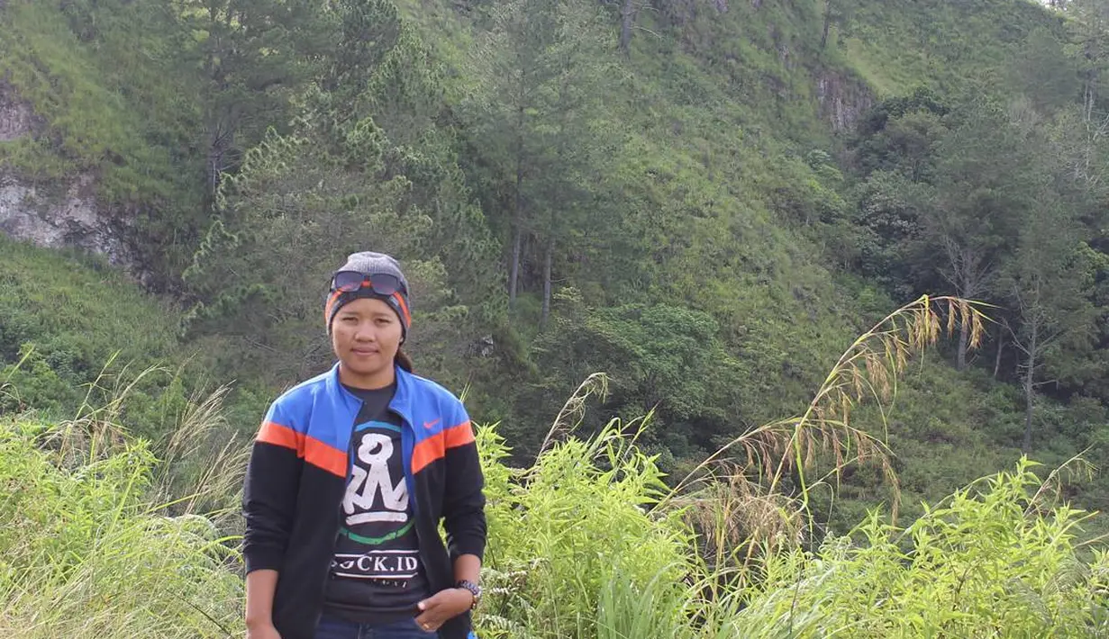 Mendaki sebuah bukit, Junita Malau tetap mengenakan jaket kesayangannya itu. Dipadkan dengan celana jeans dan t-shirt abu-abu bermotif. (instagram/junita_malau)