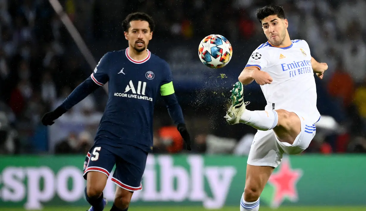 Gelandang Real Madrid Marco Asensio (kanan) berebut bola dengan bek Paris Saint Germain (PSG) Marquinhos (kiri) pada leg pertama babak 16 besar Liga Champions di Stadion Parc des Princes, Rabu dini hari WIB (16/2/2022). PSG susah payah kalahkan Real Madrid 1-0. (FRANCK FIFE / AFP)
