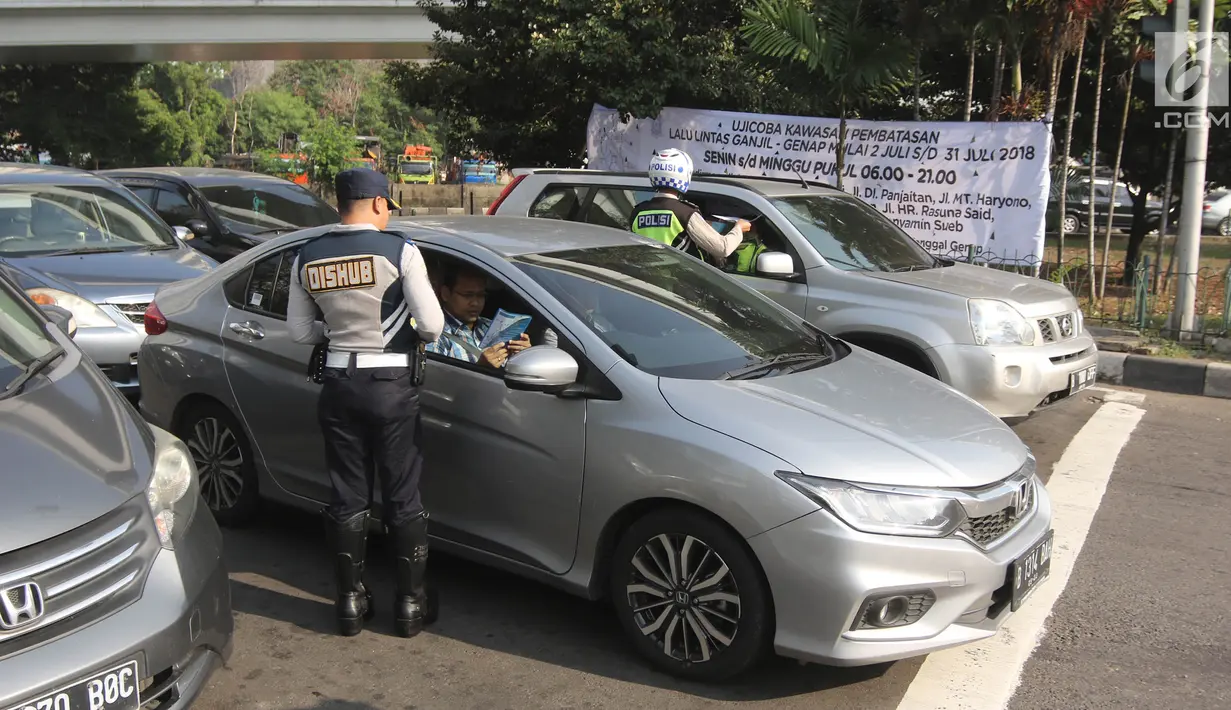 Petugas Dishub DKI membagikan selebaran untuk mensosialisasikan perluasan ganjil genap di kawasan Tomang, Jakarta, Senin (2/7). Hari ini merupakan hari pertama uji coba yang digelar jelang pelaksanaan Asian Games 2018. (Liputan6.com/Arya Manggala)