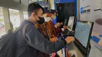 Penumpang mengambil boarding pass kereta di Stasiun Daop 8 Surabaya. (Dian Kurniawan/Liputan6.com)