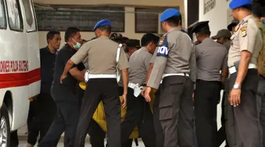 Petugas kepolisian membawa kantong jenazah masuk ke ruang jenazah di RS Bhayangkara Palu, Sulawesi Tengah, Selasa (17/7). Dua jenazah diduga teroris Santoso alias Abu Warda dan Muhtar yang tewas dalam baku tembak itu akan diidentifikasi. (OLAGONDRONK/AFP)