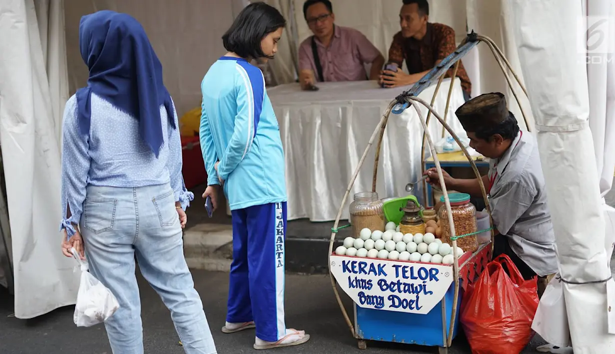 Pengunjung membeli kerak telor pada Festival Kebon Bang Jaim di Jalan Jaksa, Jakarta, Jumat (23/8/2019). Festival Kebon Bang Jaim merupakan pengganti dari Festival Jalan Jaksa yang selama ini digelar setiap tahunnya. (Liputan6.com/Immanuel Antonius)