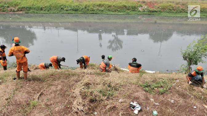 Petugas PPSU dan Sudin Tata Air Jakarta Timur membersihkan sampah dan tanaman liar di sepanjang aliran Kanal Banjir Timur (KBT), Senin (15/10). Banyak sampah yang bermunculan ke permukaan akibat debit air surut. (Merdeka.com/ Iqbal S. Nugroho)