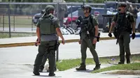 Aparat penegak hukum berdiri di luar Robb Elementary School setelah penembakan, Uvalde, Texas, Amerika Serikat, 24 Mei 2022. Ini merupakan insiden paling parah dalam sejarah Texas. (AP Photo/Dario Lopez-Mills)