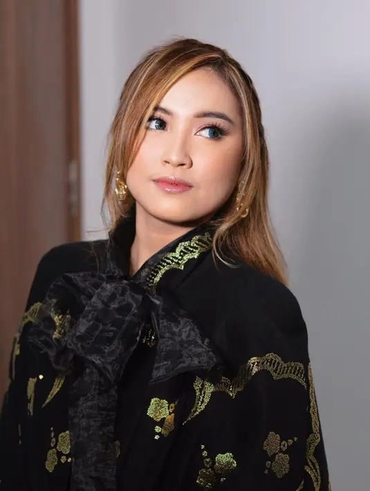 Pesonanya semakin terpancar ketika memakai gaun hitam dengan motif emas. Ditambah dengan makeup natural serta rambut pirang, remaja 19 tahun ini pun banjir pujian. (Liputan6.com/IG/@lebbywilayati)