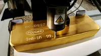 Pekerja menggunakan mesin untuk memberikan nomor seri pada emas batangan di pabrik logam mulia Krastsvetmet, Rusia, 24 Oktober 2016. Krastsvetmet merupakan salah satu produsen terbesar di dunia dalam industri logam mulia (Reuters/Ilya Naymushin)