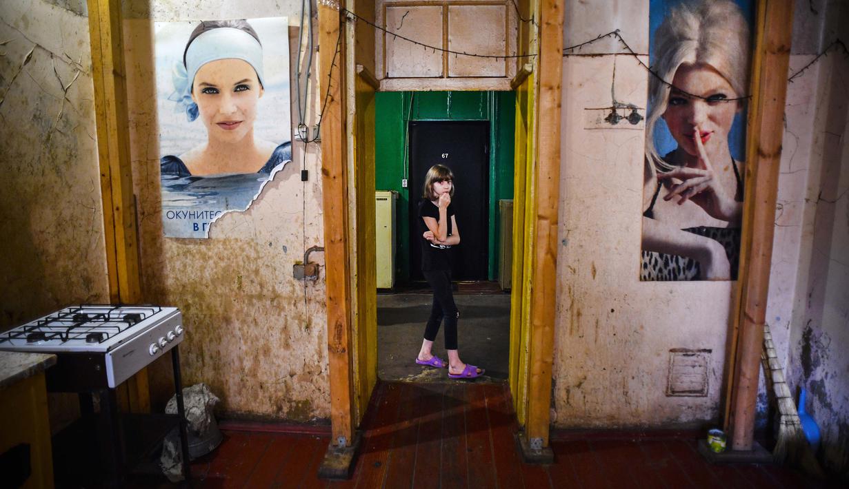 Seorang anak berjalan melewati pintu masuk dapur umum asrama pekerja pabrik tekstil Proletarka di Kota Tver, Rusia, 8 Agustus 2020. Kota Tver yang unik serta padat dilupakan oleh otoritas baru dan diubah menjadi ghetto miskin yang kotor. (Alexander NEMENOV/AFP)