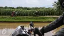 Sejumlah pemudik motor menerobos jalan perkampungan melewati ladang jagung di kawasan Ketanggungan, Kabupaten Brebes, Jateng, Senin (4/06). Jalan yang melintasi sepanjang kali ini, menjadi pemandangan bagi pemudik roda empat. (Liputan6.com/Fery Pradolo)
