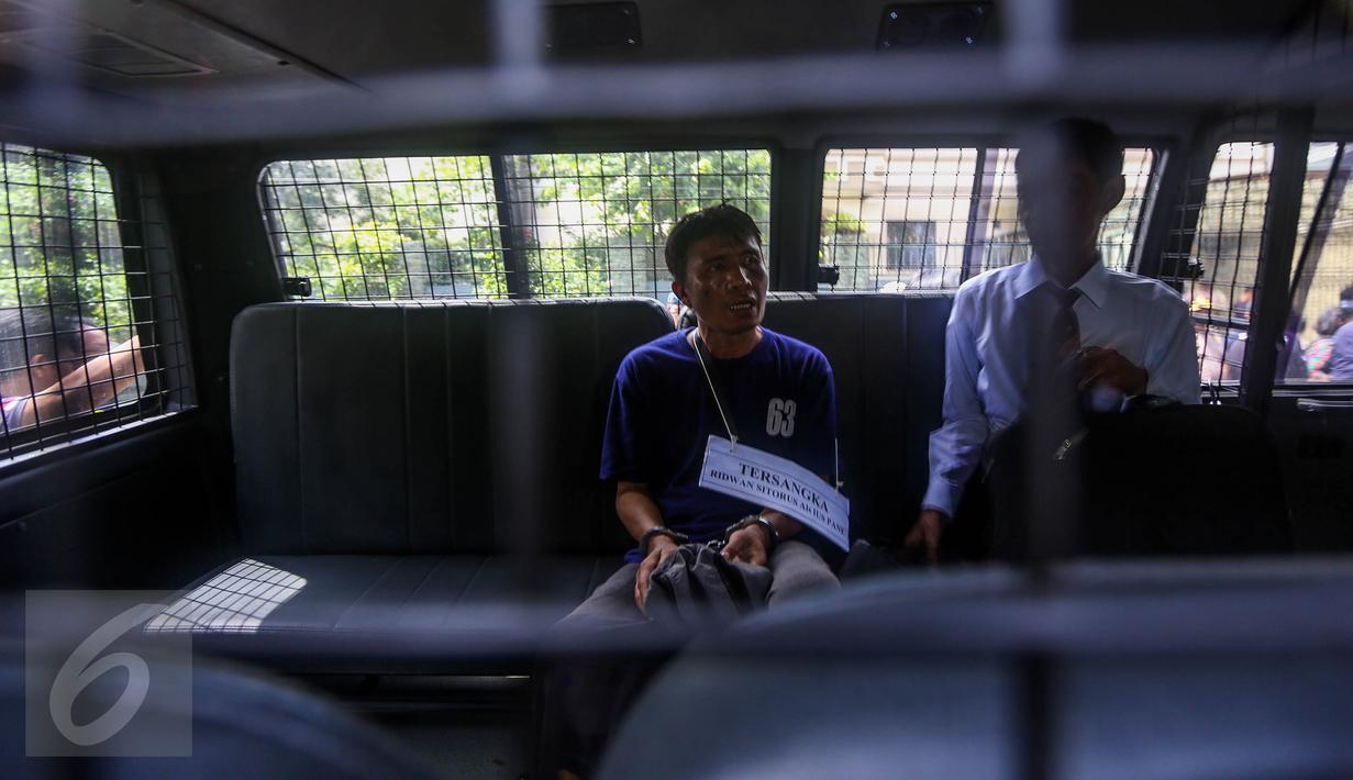 Tersangka Ridwan Sitorus alias Ius Pane seusai menjalani prarekonstruksi kasus perampokan dan pembunuhan di perumahan Pulomas, Jakarta Timur, Jumat (6/1). Sebanyak 71 adegan dilakukan untuk kelengkapan pemeriksaan. (Liputan6.com/Faizal Fanani)