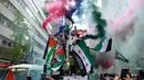 Demonstran memegang bendera Palestina dan Suriah untuk mendukung Palestina di tengah Kota Manhattan, New York City, Amerika Serikat, 18 Mei 2021. Demonstrasi mendukung Palestina atas konflik yang telah berlangsung lebih dari seminggu terjadi di sejumlah negara. (Angela Weiss/AFP)