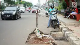 Kendaraan melintas di samping bekas galian proyek yang tidak tuntas pengerjaannya di Jalan Margonda Raya, Depok, Jawa Barat, Kamis (9/5/2019). Kondisi jalan yang diabaikan selama beberapa bulan terakhir tersebut memersempit dan mengganggu aktivitas warga. (Liputan6.com/Immanuel Antonius)