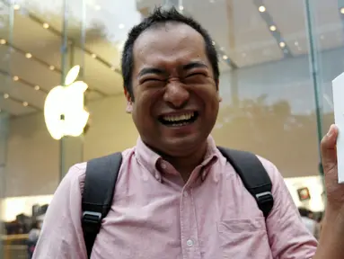 Sho Inoue menunjukkan iPhone 7 usai membeli di Apple Store di Tokyo, Jepang, Jumat (16/9). Pembeli iPhone7 hari ini menjadi bagian dari pembeli pertama di seluruh dunia. (REUTERS / Issei Kato)