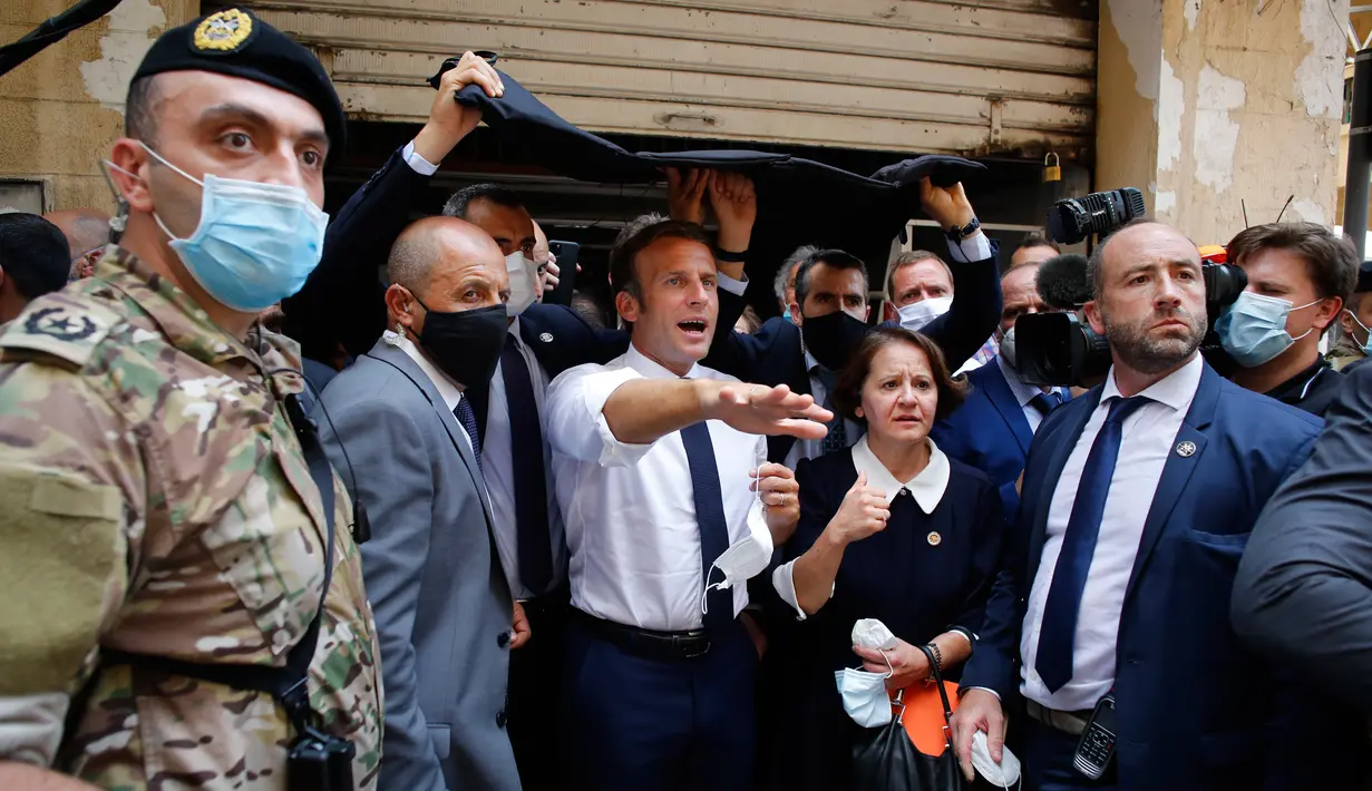 Presiden Prancis Emmanuel Macron (tengah) mengunjungi lokasi ledakan yang menghancurkan di pelabuhan Beirut, Lebanon, Kamis (6/8/2020). Presiden Macron tiba di Beirut untuk menawarkan bantuan Prancis ke Lebanon setelah ledakan besar yang meluluhlantakkan Kota Beirut. (AP Photo/Thibault Camus, Pool)