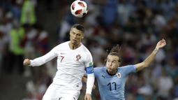 Duel pemain Portugal, Cristiano Ronaldo (kiri) dan pemain Uruguay, Diego Laxalt pada laga 16 besar Piala Dunia 2018 di Fisht Stadium, Sochi, Rusia, (30/6/2018). Portugal kalah 1-2. (AP/Andrew Medichini)