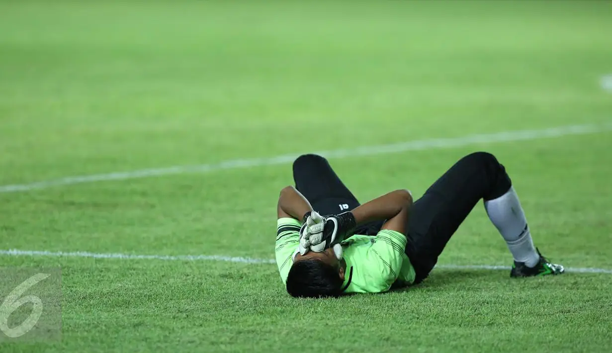 Penjaga gawang Sulawesi Selatan, Syaiful menutup wajah usai dikalahkan Jawa Barat di laga final PON XIX 2016 di Stadion Si Jalak Harupat, Kab Bandung, Rabu (28/9). Sulsel kalah adu penalti 5-4. (Liputan6.com/Helmi Fithriansyah)