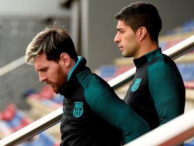 Barcelona tetap berlatih serius jelang menjamu Borussia Monchengladbach walau sudah lolos ke-16 besar Liga Champions. Lionel Messi dan Luis Suarez saat akan memulai latihan. (AFP/Lluis Gene)